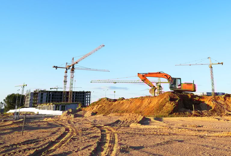 Modern residential construction with professional tower cranes and excavation work