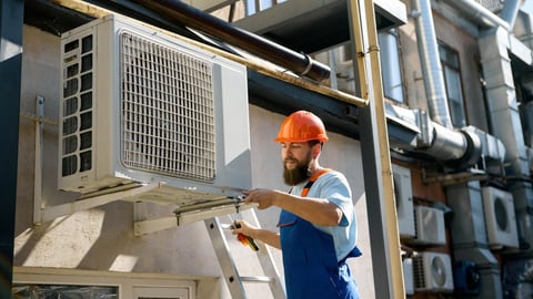 Technician installing HVAC unit outdoors with professional expertise